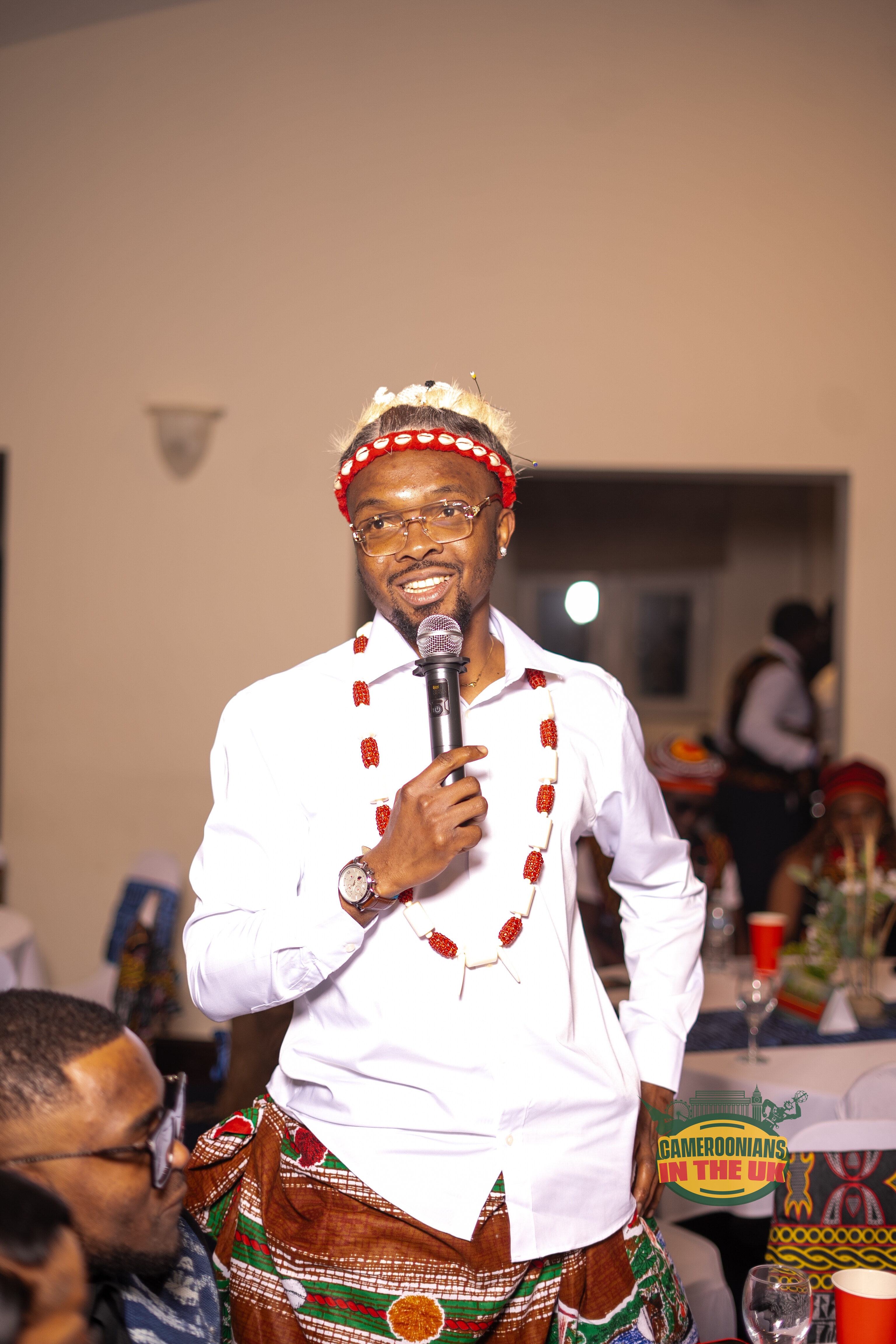 A CAMUK member in traditional regalia speaking at a community event